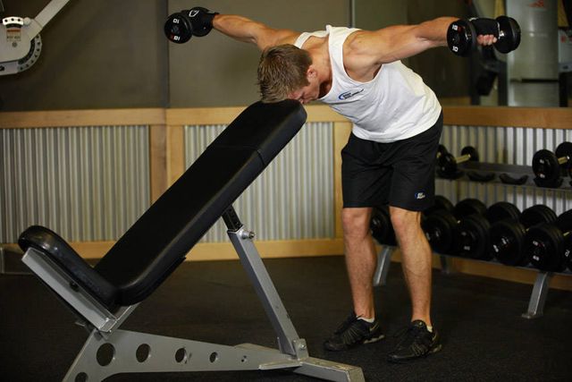 Bent Over Dumbbell Rear Delt Raise With Head On Bench: finishing position