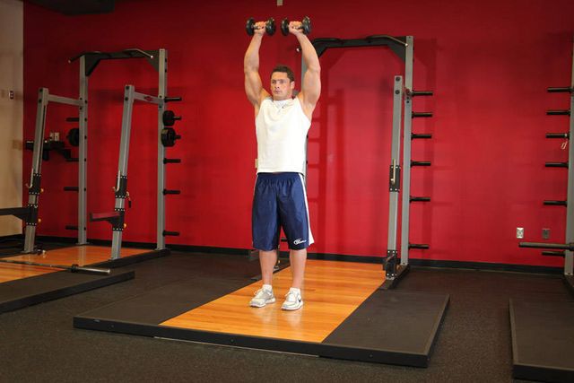 Standing Dumbbell Straight-Arm Front Delt Raise Above Head: finishing position